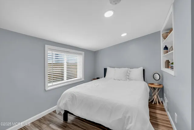 a bedroom with a bed and wooden floor