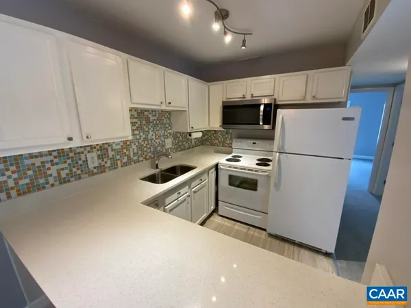 a kitchen with stainless steel appliances a refrigerator sink and microwave
