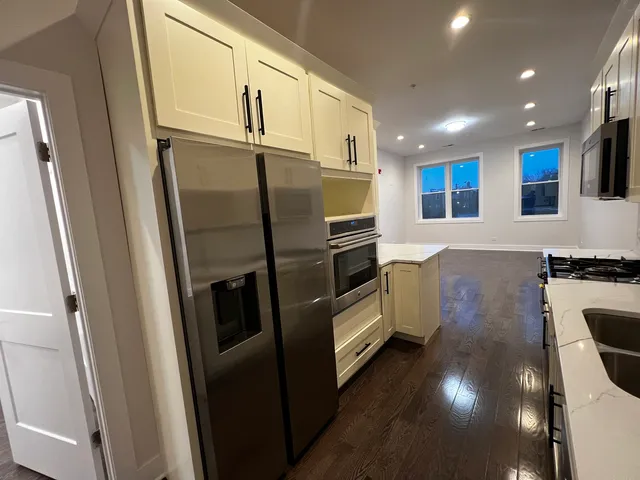 a kitchen with stainless steel appliances a refrigerator a sink a stove and cabinets