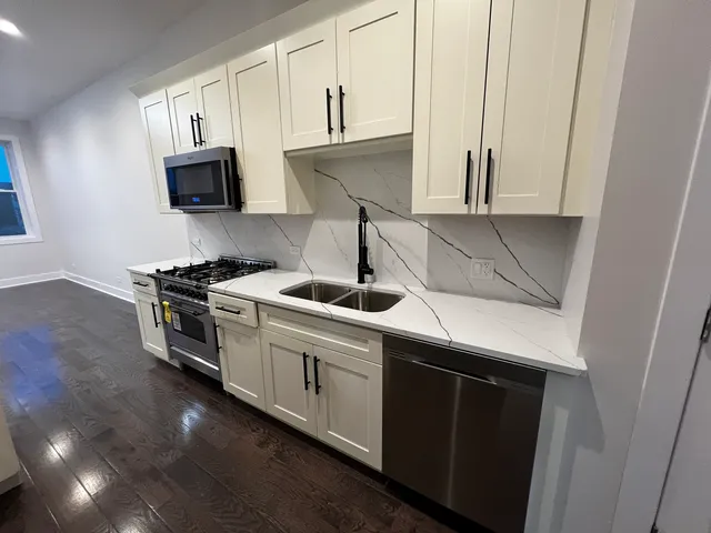 a kitchen with stainless steel appliances a sink stove and microwave