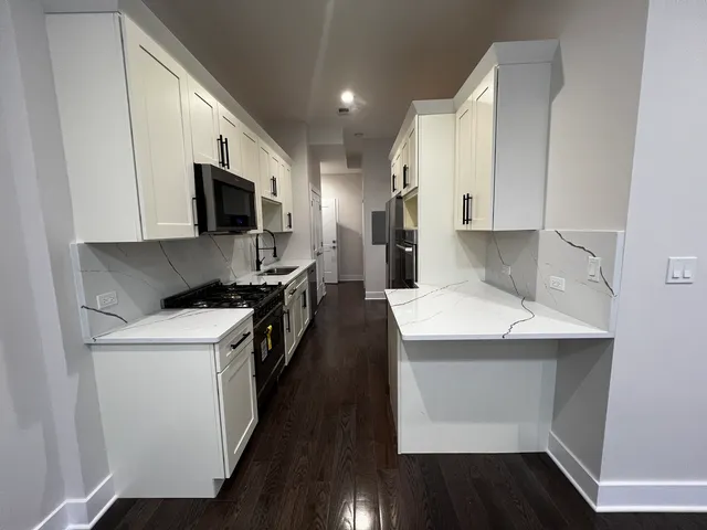 a kitchen with a sink a microwave a stove and refrigerator
