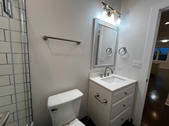 a bathroom with a sink a toilet and mirror