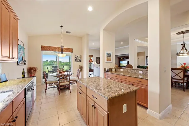 a kitchen with granite countertop a stove and a view of living room