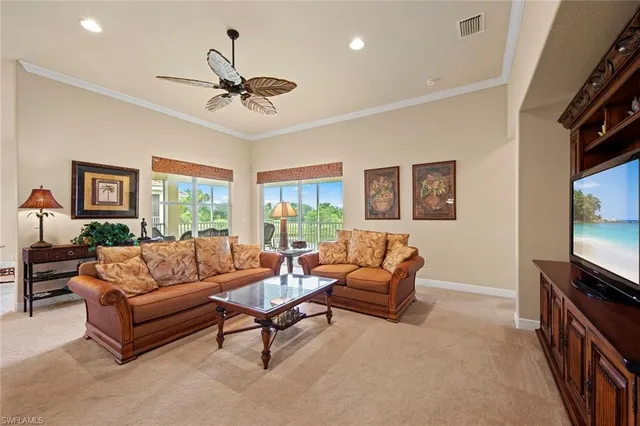 a living room with furniture a chandelier and a flat screen tv