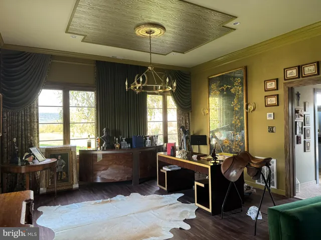 a view of a hallway with wooden floor and a living room