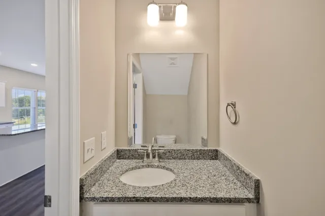 a bathroom with a granite countertop sink and a mirror