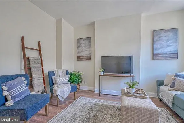 a kitchen with stainless steel appliances granite countertop a stove top oven a sink a dining table and chairs with wooden floor