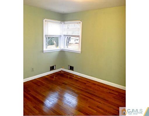 786 Old Raritan Road Edison, NJ 08820 - Photo 16 of 17 a room with a wooden floor and a window