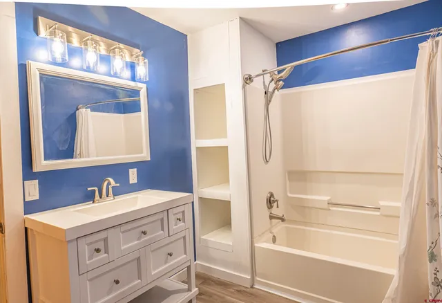 a bedroom with a bed and wooden floor