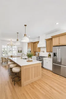 a large kitchen with cabinets wooden floor and stainless steel appliances