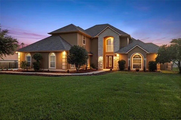 a front view of a house with yard and green space