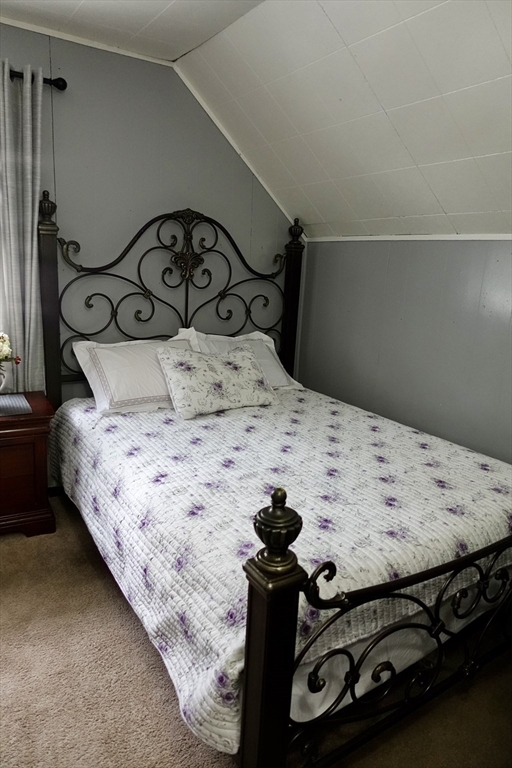 5 Vernon Street Holyoke, MA 01040 - Photo 11 of 12 a bed sitting in a bedroom next to a window and a mirror