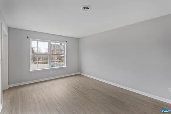an empty room with wooden floor and window