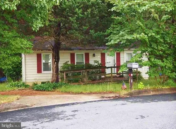 a front view of a house with garden and trees