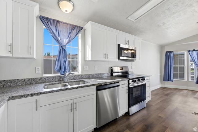 150 West 7500th South, Unit 55 Midvale, UT 84047 - Photo 15 of 28 Kitchen featuring white cabinetry with brushed nickel hardware, granite-look countertops, and stainless steel appliances including a range, microwave, and dishwasher