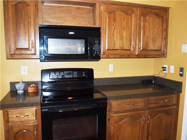 2848 Bolton Road Columbia, TN 38401 - Photo 9 of 20 a kitchen with granite countertop wood cabinets and a stove top oven