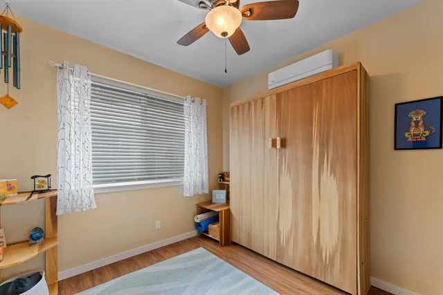 a view of a livingroom with a chandelier fan and wooden floor