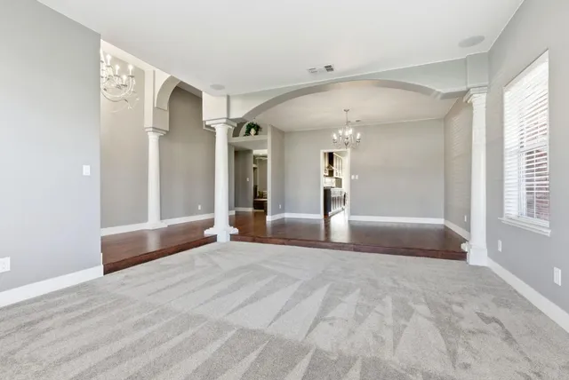 a view of a room with wooden floor and chandelier