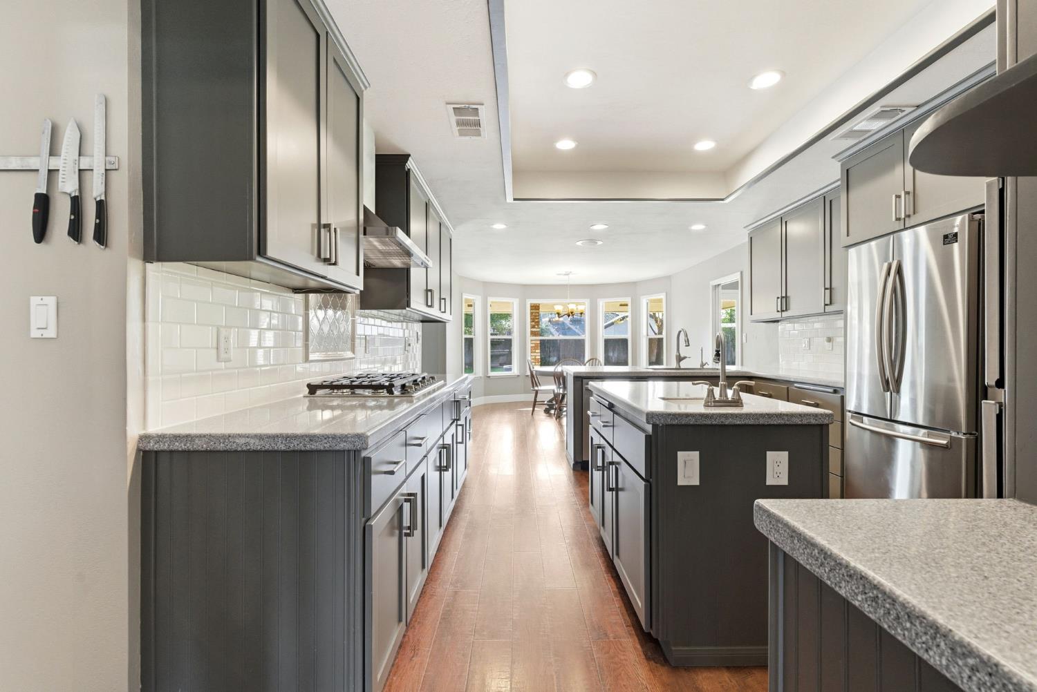 13201 Meacham Road Bakersfield, CA 93314 - Photo 25 of 62 a kitchen with stainless steel appliances granite countertop a stove top oven a sink and dishwasher