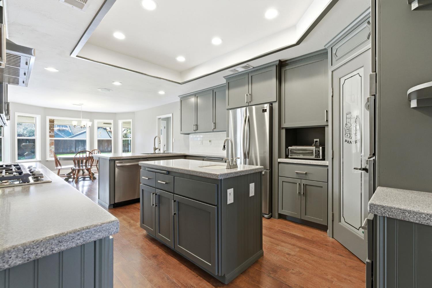 13201 Meacham Road Bakersfield, CA 93314 - Photo 26 of 62 a kitchen with stainless steel appliances granite countertop a refrigerator a sink a stove and a wooden floors