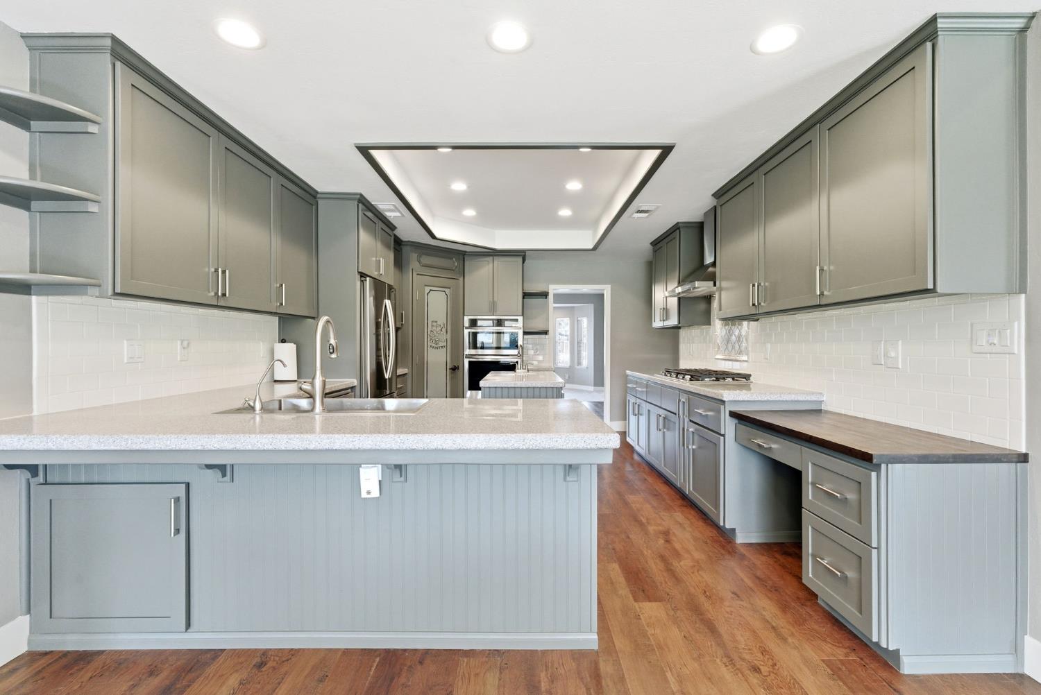 13201 Meacham Road Bakersfield, CA 93314 - Photo 31 of 62 a kitchen with stainless steel appliances granite countertop a sink a stove and a wooden floors