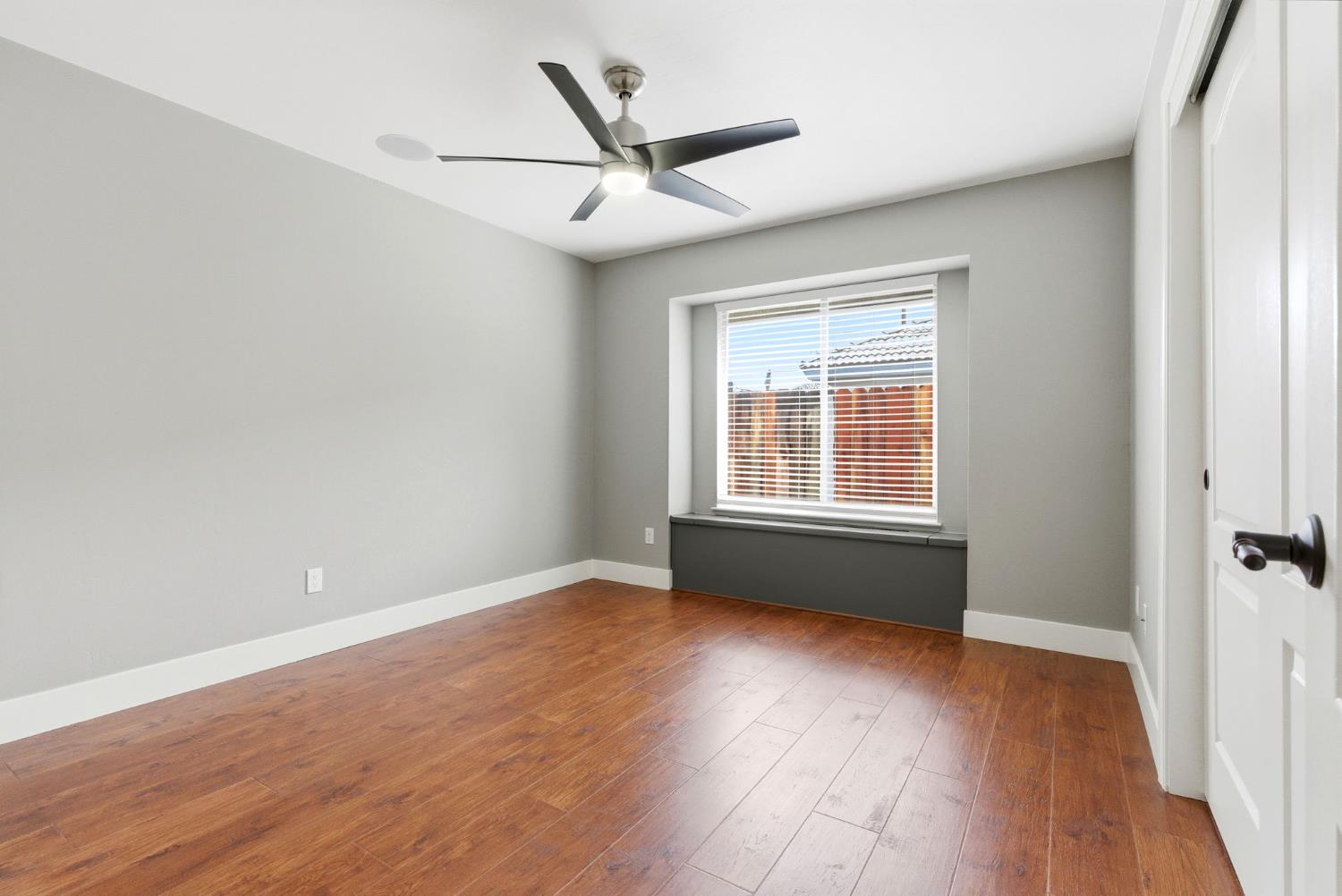 13201 Meacham Road Bakersfield, CA 93314 - Photo 40 of 62 an empty room with wooden floor fan and windows
