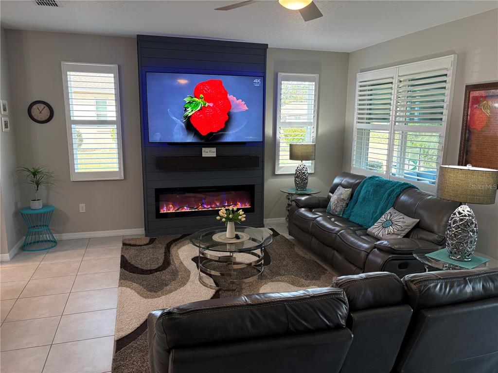 7819 Southwest 88th St Road Ocala, FL 34476 - Photo 12 of 30 a living room with furniture a fireplace and a flat screen tv