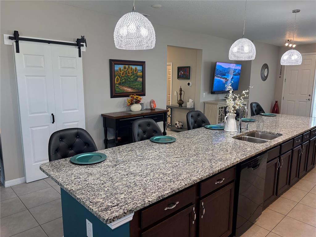 7819 Southwest 88th St Road Ocala, FL 34476 - Photo 9 of 30 a kitchen with kitchen island granite countertop a table and a chandelier
