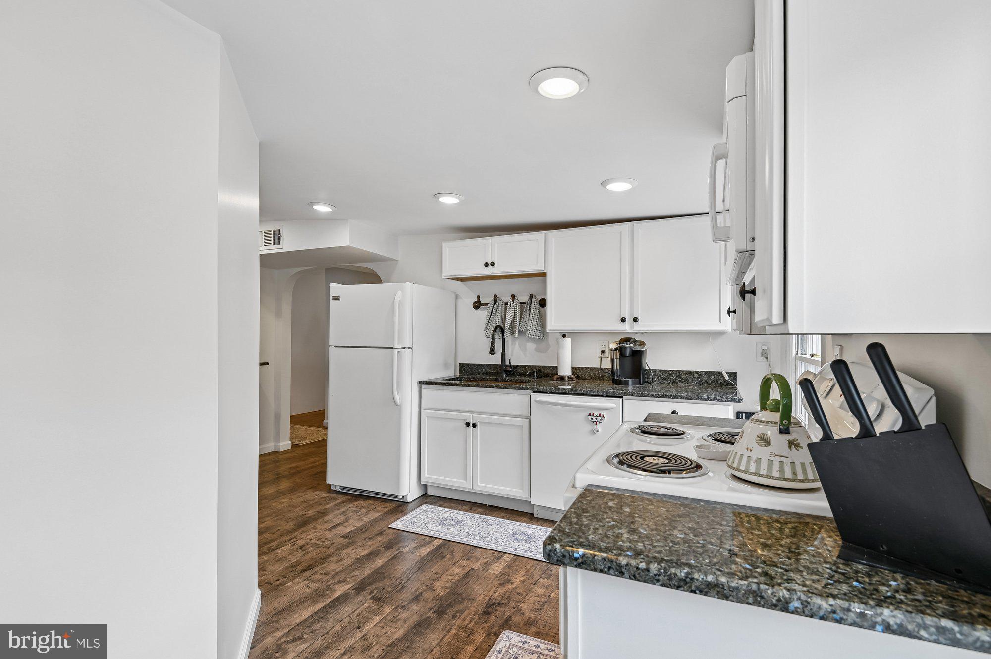 8 Fleet Street Annapolis, MD 21401 - Photo 20 of 37 a kitchen with stainless steel appliances granite countertop a refrigerator a sink dishwasher a stove and white countertops with wooden floor