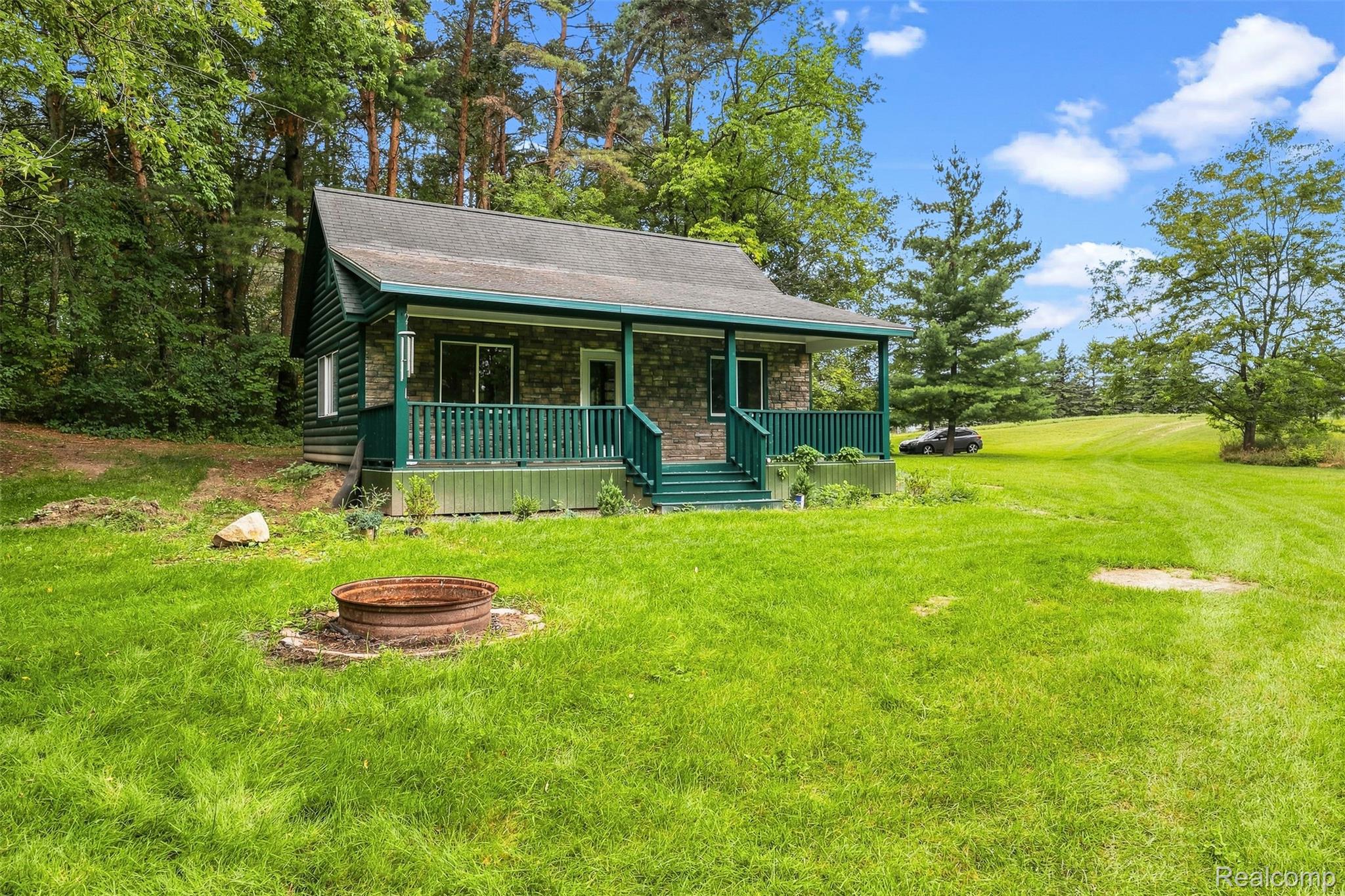 Stone and siding exterior with a covered front porch featuring a railing and steps