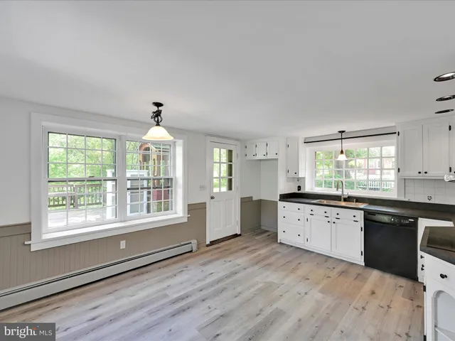 a living room with a dining table wooden floor and a fireplace