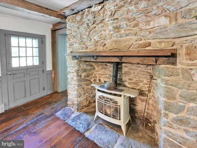 an empty room with wooden floor fireplace and windows