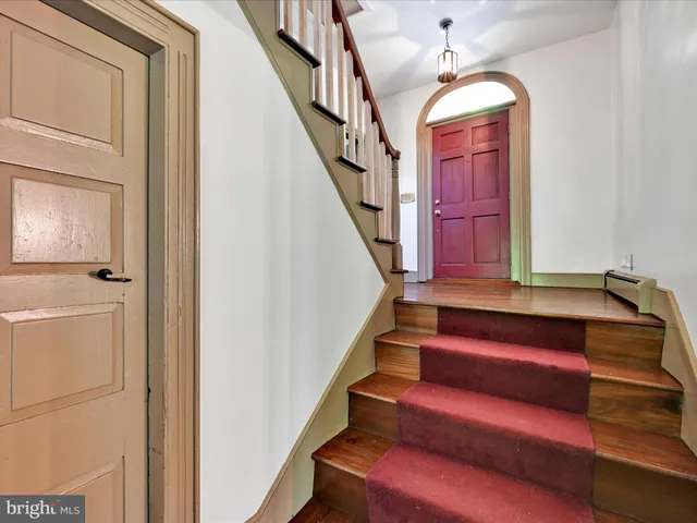 a view of empty room with a fireplace and wooden floor