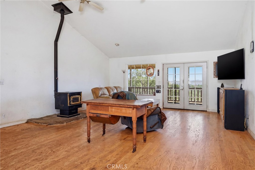 16965 Spruce Grove Road Hidden Valley Lake, CA 95467 - Photo 6 of 34 a living room with furniture a flat screen tv and a floor to ceiling window