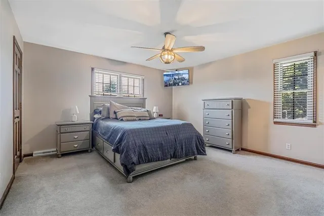 a bedroom with a large bed and ceiling fan