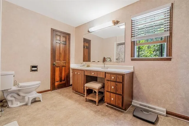 a bathroom with a toilet a sink and a mirror