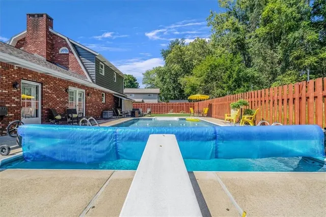 a view of backyard with swimming pool and deck