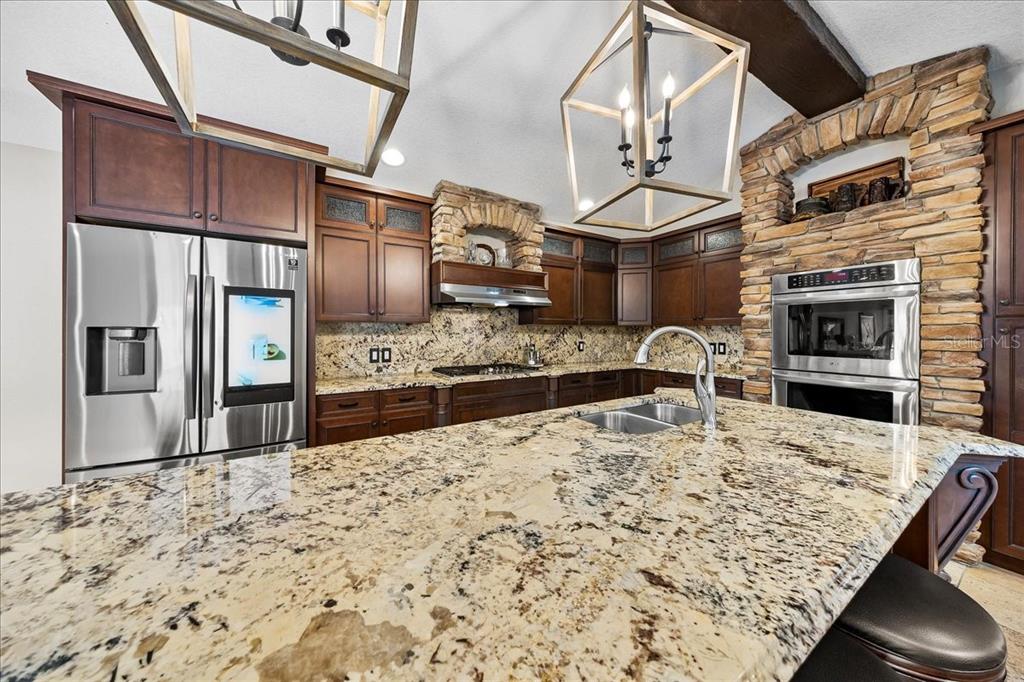 452 Southeast Paradise Point Road Crystal River, FL 34429 - Photo 52 of 83 a kitchen with kitchen island granite countertop a stove and refrigerator