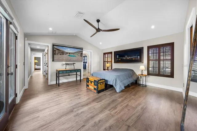 a spacious bedroom with a bed a dresser and a chandelier