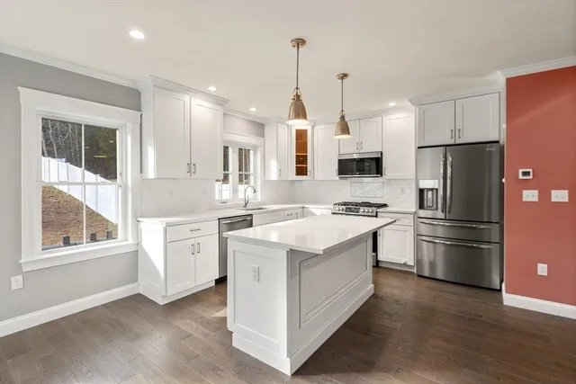 a kitchen with white cabinets and stainless steel appliances
