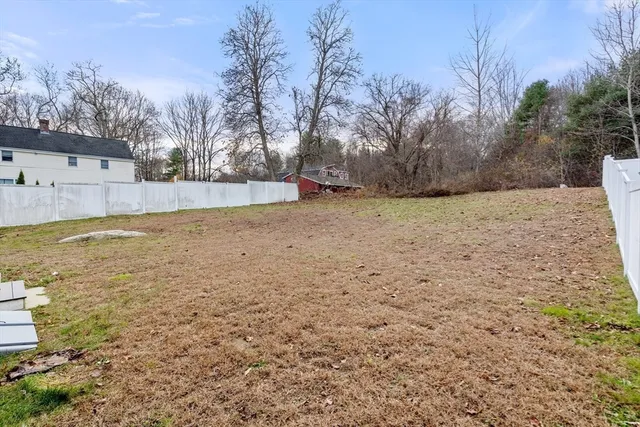a view of a house with a yard and fence