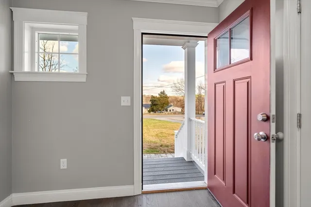 a view of a hallway with wooden floor and windows