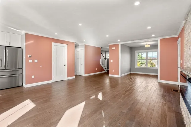 a view of an empty room with window and wooden floor