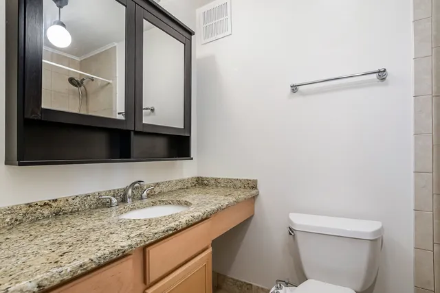 a bathroom with a granite countertop sink and a mirror