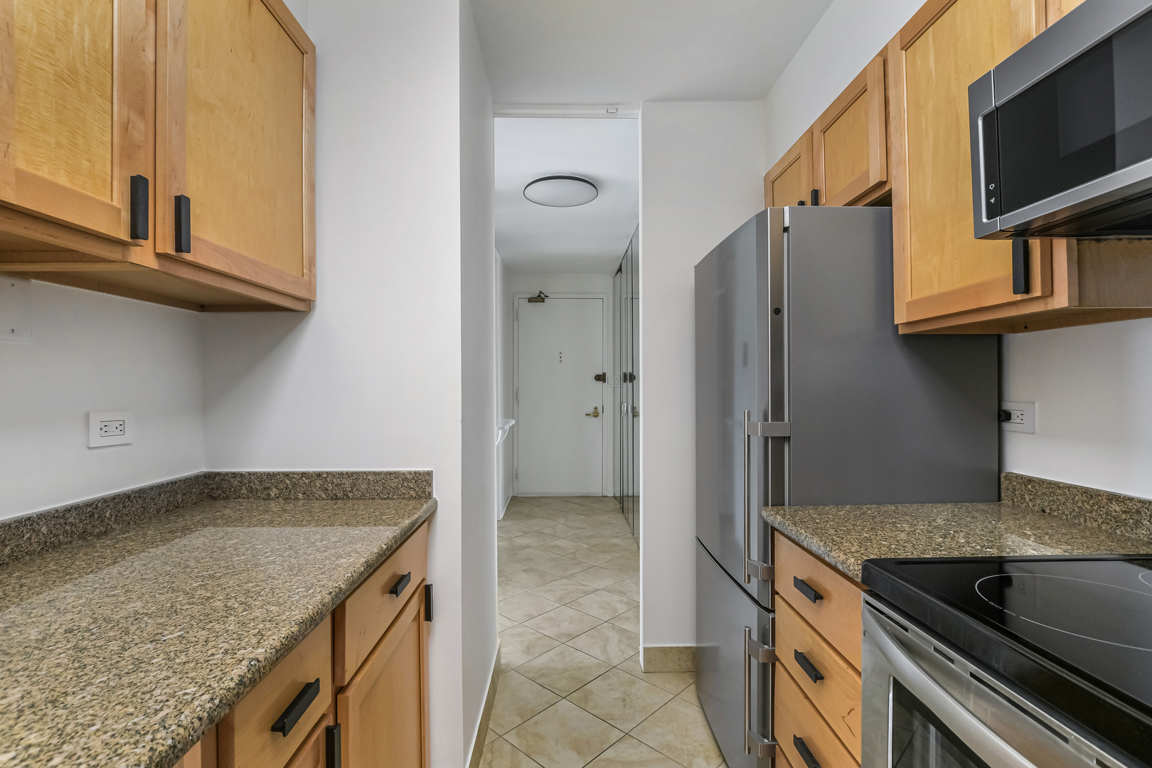 100 East Walton Street, Unit 26A Chicago, IL 60611 - Photo 7 of 23 a kitchen with granite countertop a sink and a stove