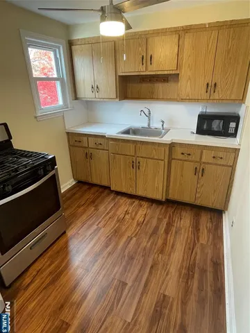 a kitchen with sink a microwave and cabinets