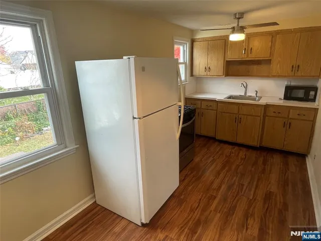 a kitchen with a refrigerator a sink and cabinets