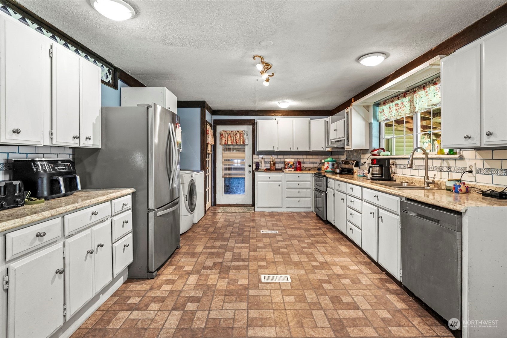 455 Drews Prairie Road Toledo, WA 98591 - Photo 8 of 31 a large kitchen with stainless steel appliances kitchen island granite countertop a refrigerator oven a sink dishwasher and white cabinets with wooden floor