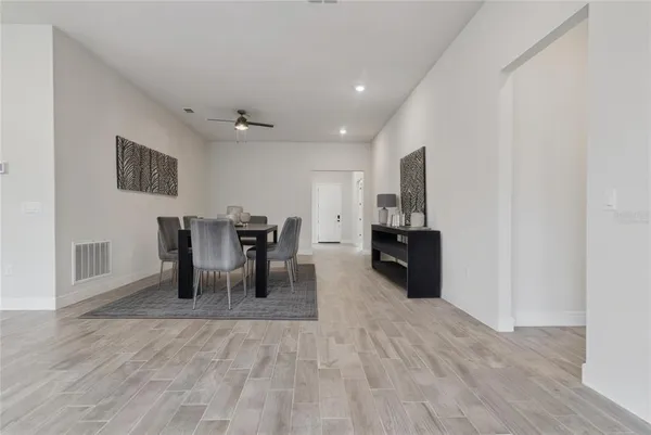 a view of a livingroom with wooden floor and a ceiling fan