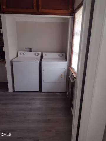a utility room with wooden floor washer and dryer